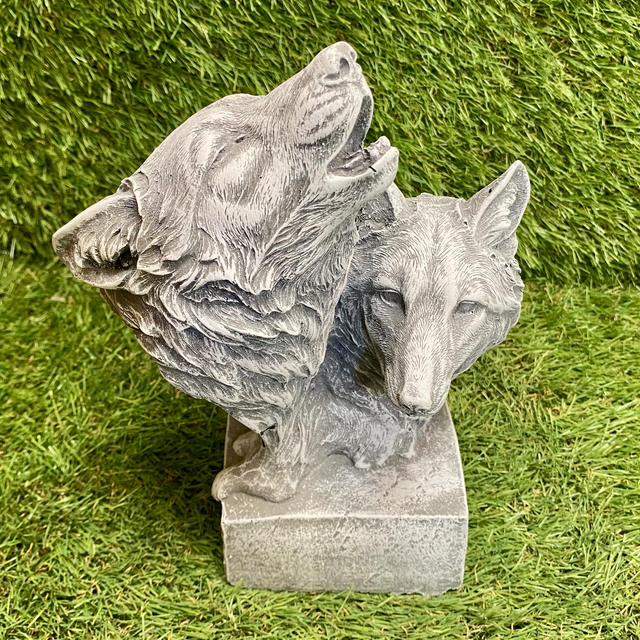 Statue of two wolves on a grassy background