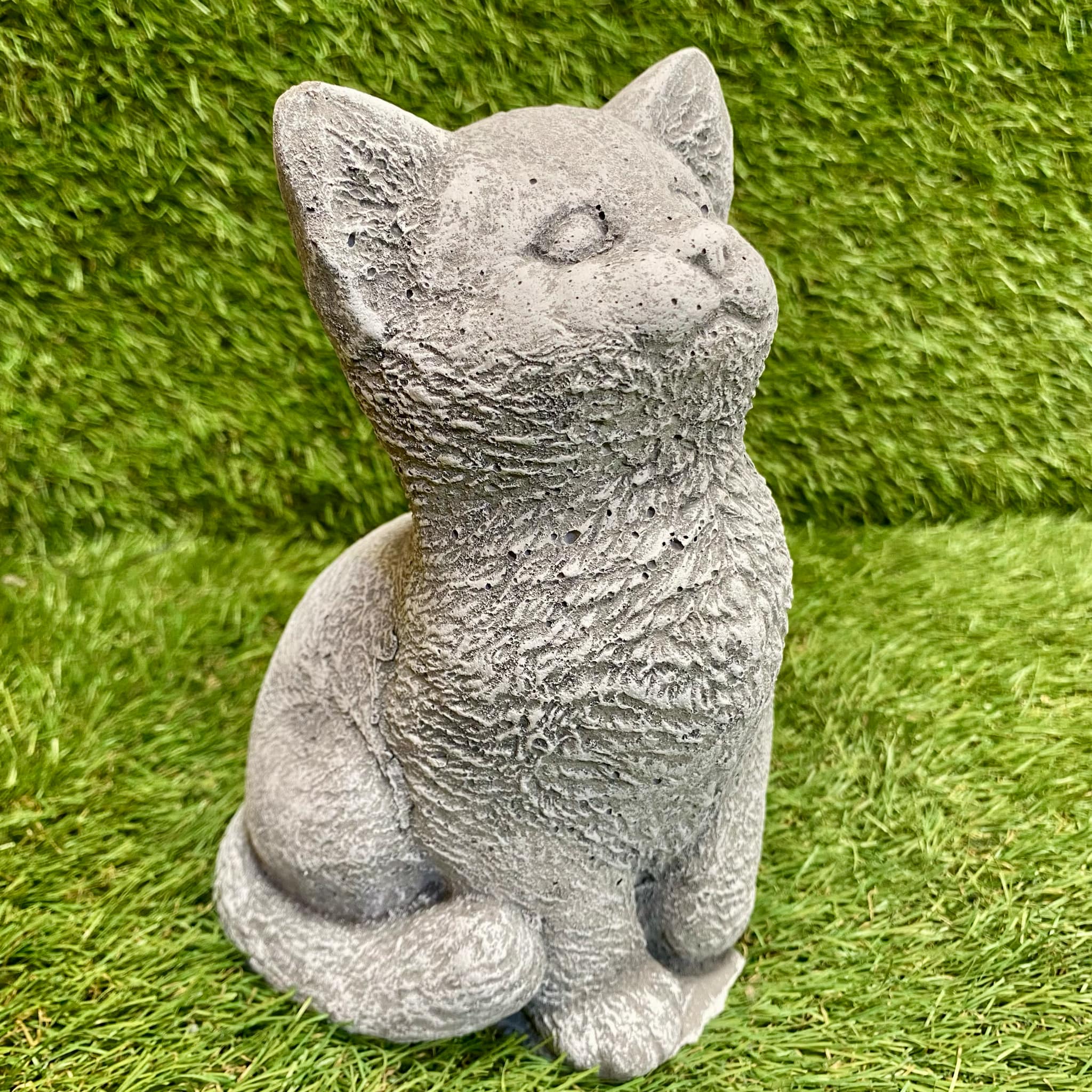 Stone cat statue on grass