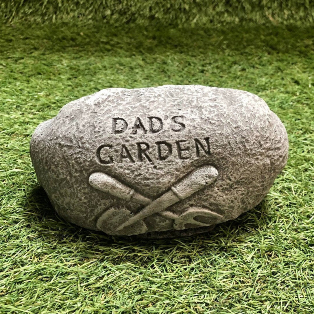 Decorative stone with 'DAD'S GARDEN' engraving on a grass background